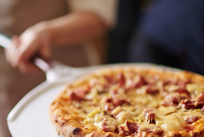 Italian pizza Traditional pizza being taken out of oven